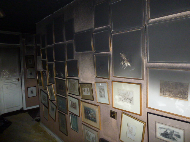Framed artwork affected by smoke and soot following a residential fire